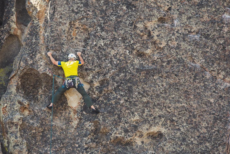 man climbing a rock - (Can Beginners use aggressive Climbing Shoes)