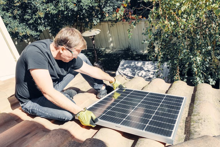 man setting up a solar panel - (How to set up Solar for Camping)