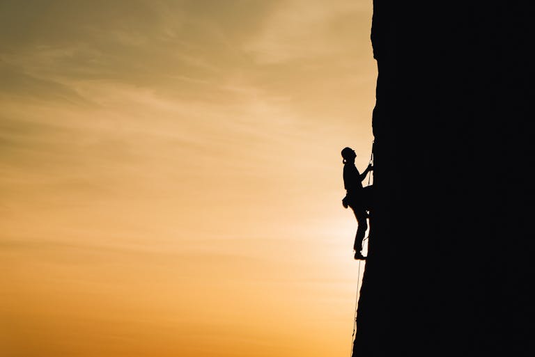 man climbing a rock - (best beginner rock climbing shoes)